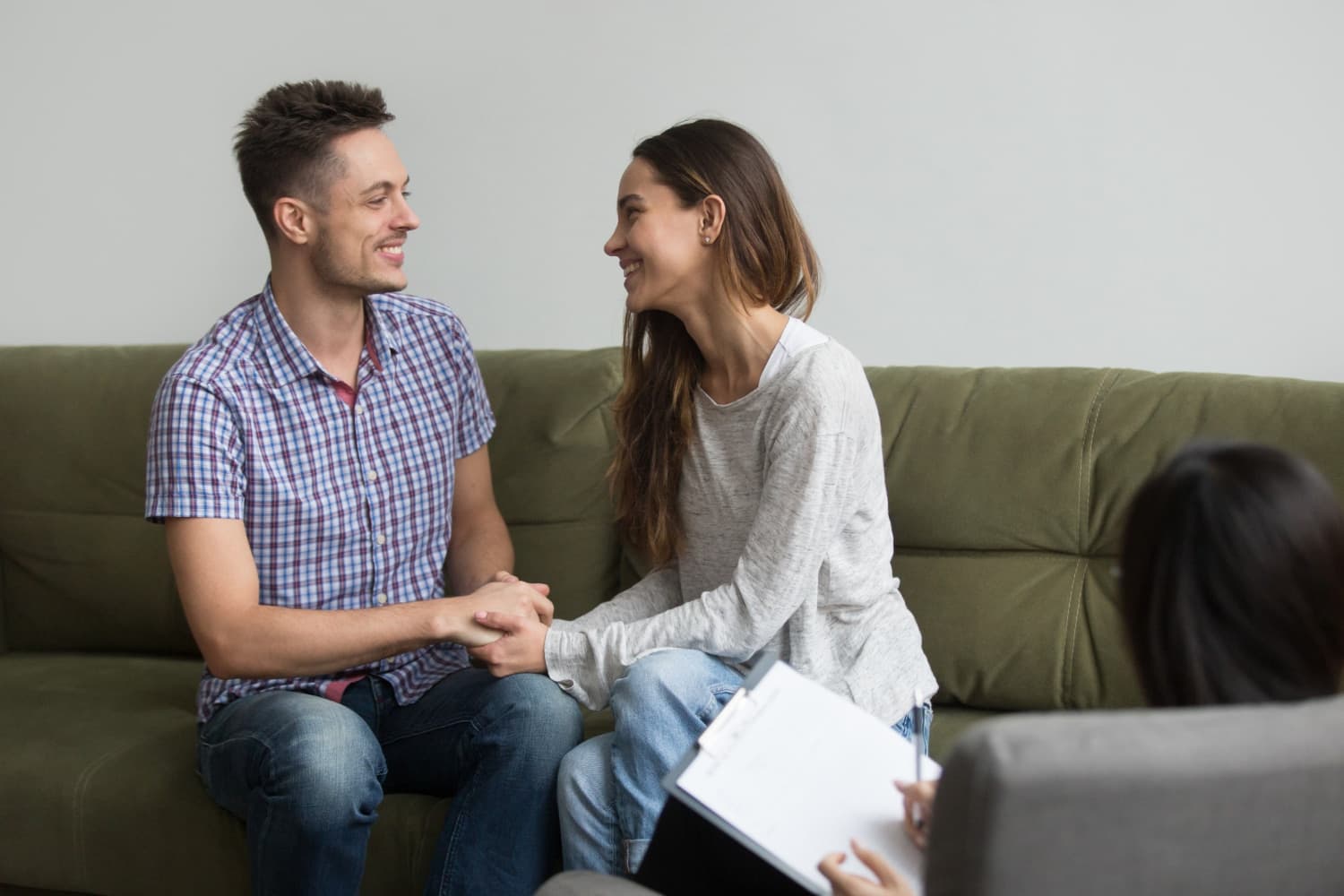 A couple holding each other's hands and working collaboratively during a couples therapy session.
