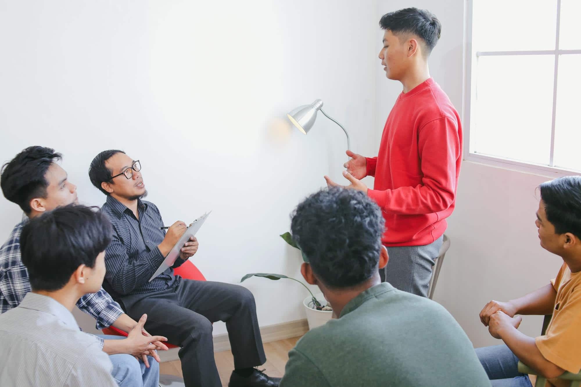 A group of Asian men engaging in group counselling in Singapore.