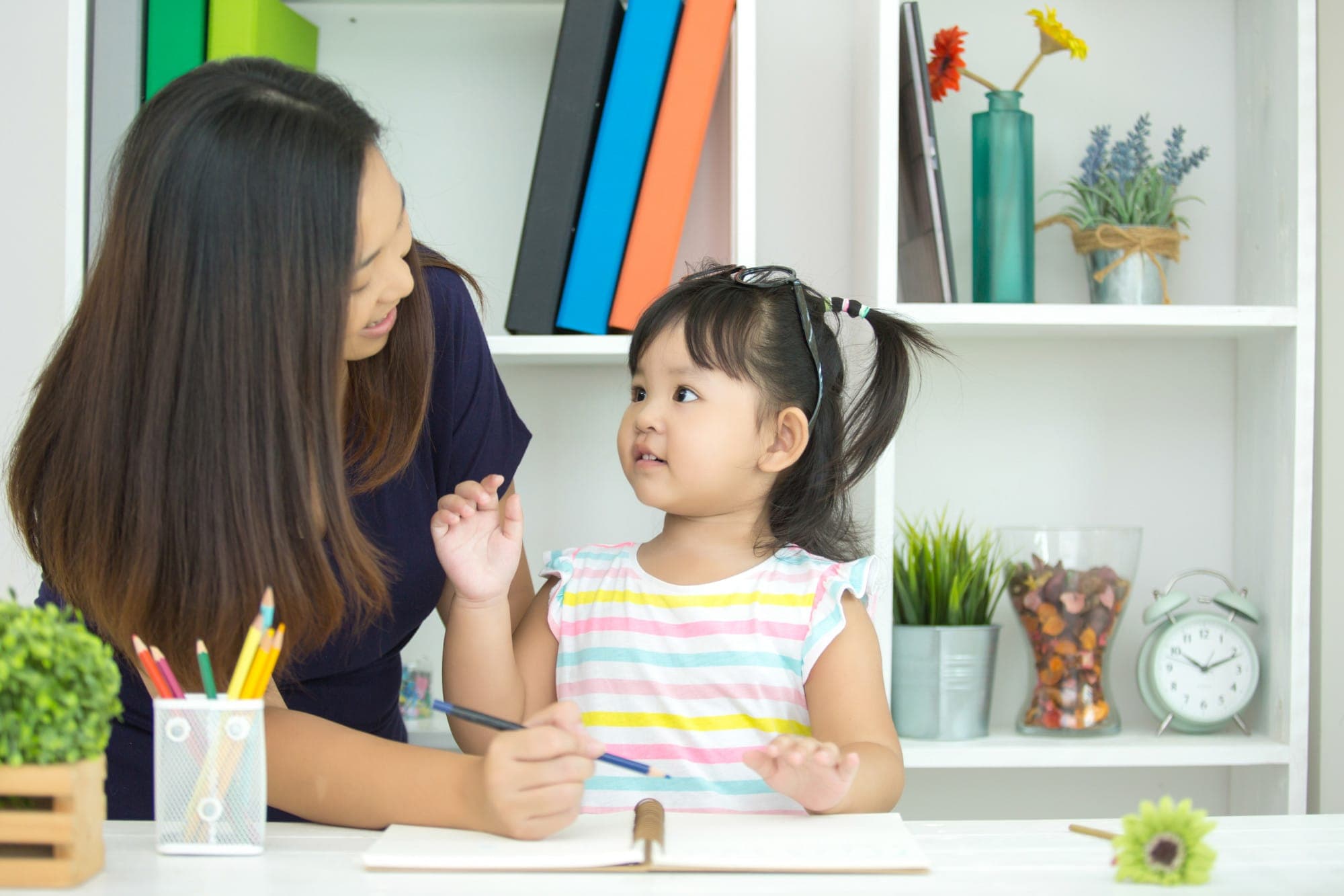 A child psychologist engaging in art therapy with a child in Singapore.