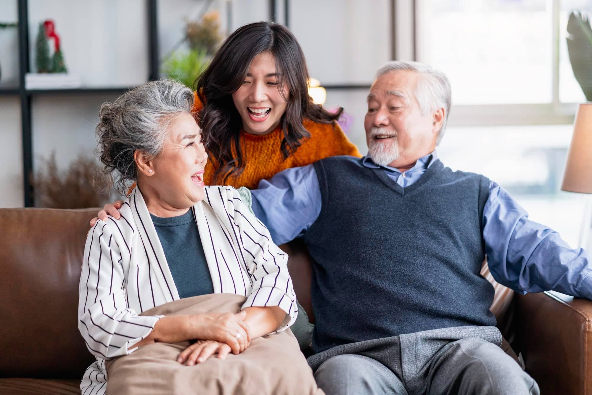 A happy elderly Asian couple with their adult daughter.