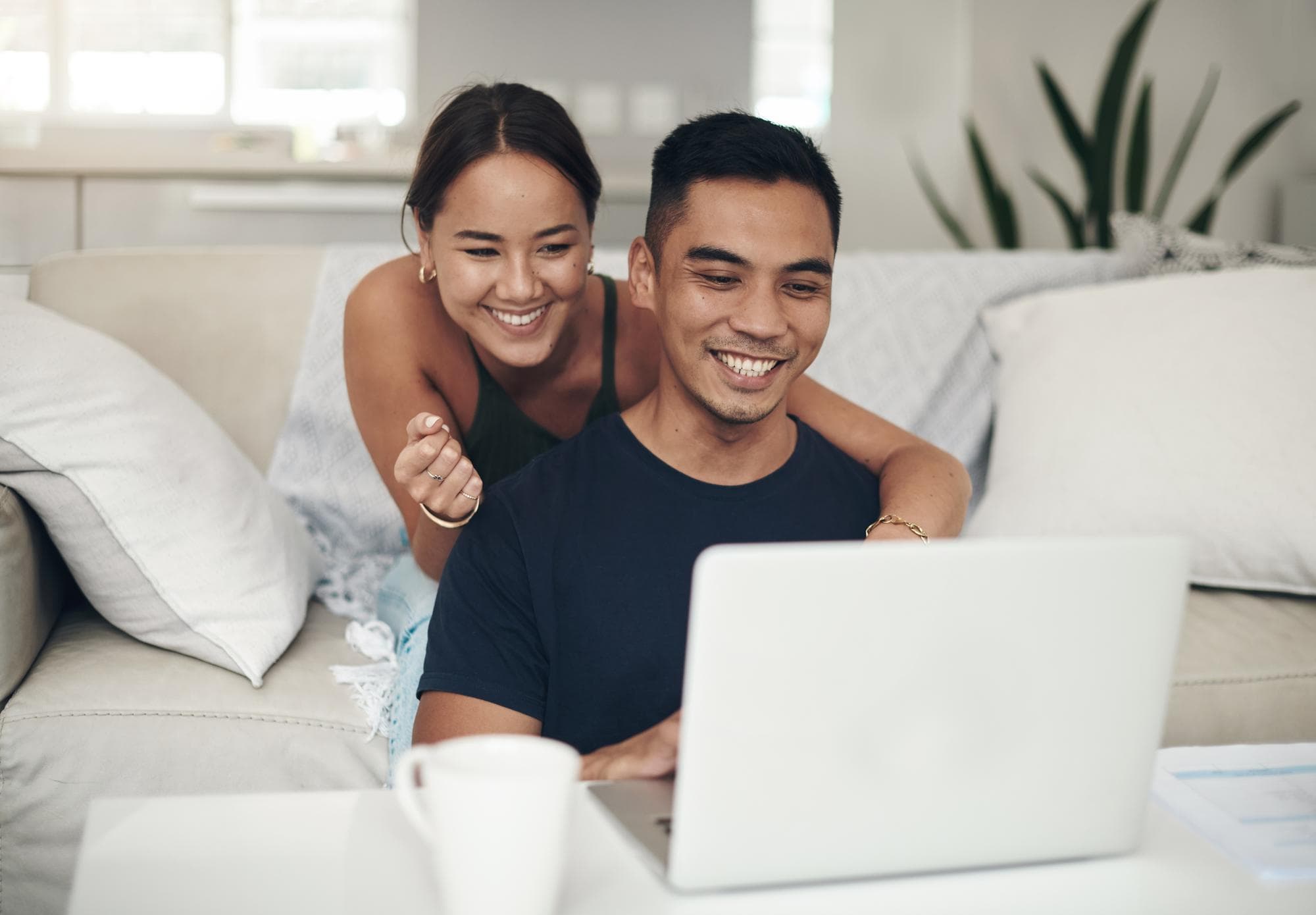 An Asian couple looking visibly happy after an online couples therapy session.