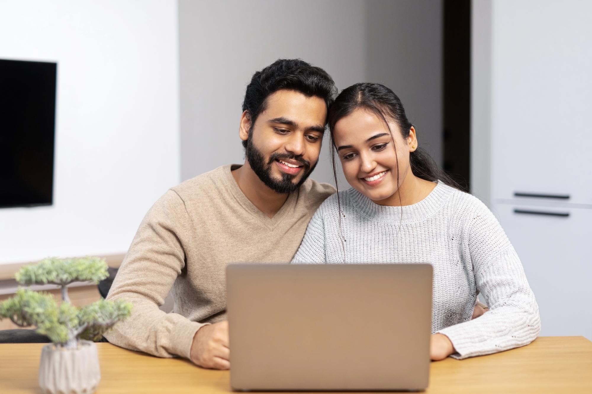 An Asian couple engaging in an online couples therapy session.