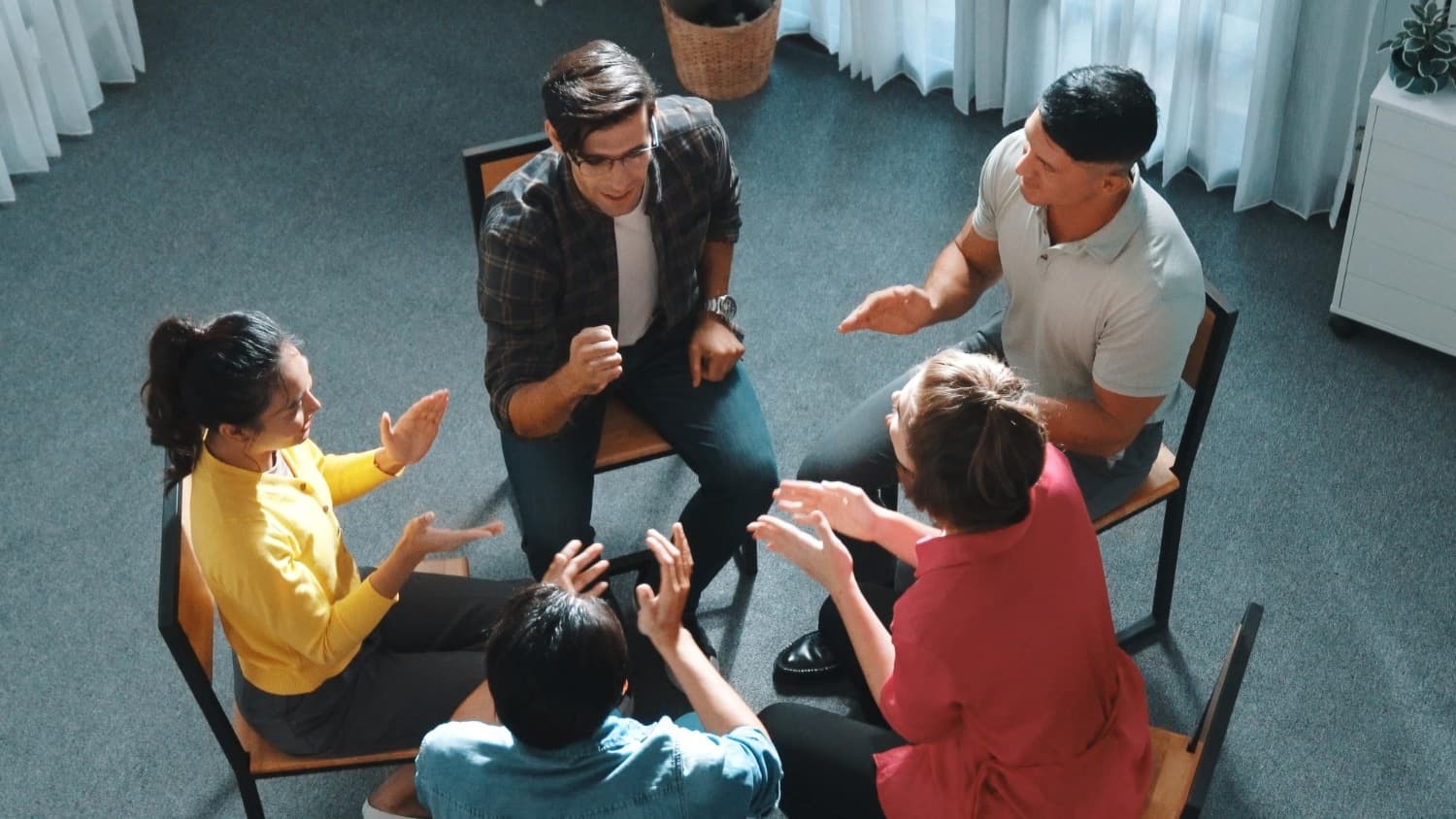 A group of five people engaging in group counselling in Singapore.