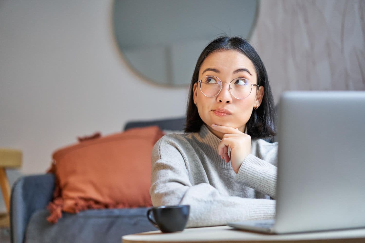 A person sitting before a laptop and wondering about "How Online Counselling is Changing Mental Health Support".