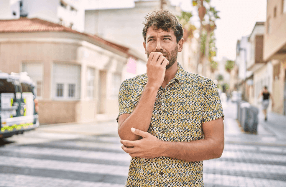 A man standing in the road and having symptoms of agoraphobia