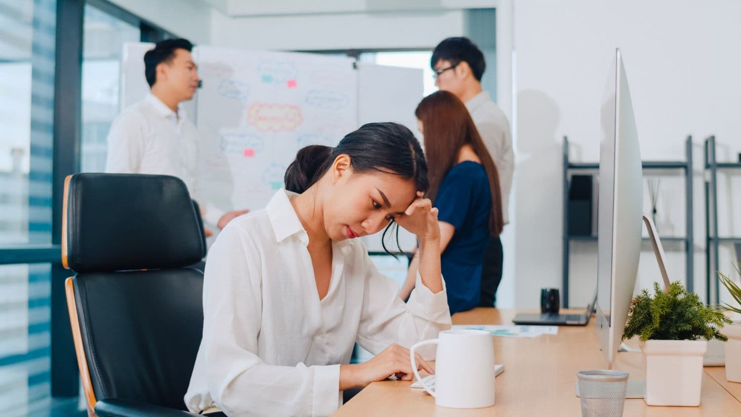 A Singaporean woman with Type A Personality experiencing signs of burnout at work.