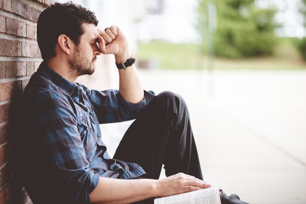 A person sitting and looking upset due to suffering from a common mental health issue.
