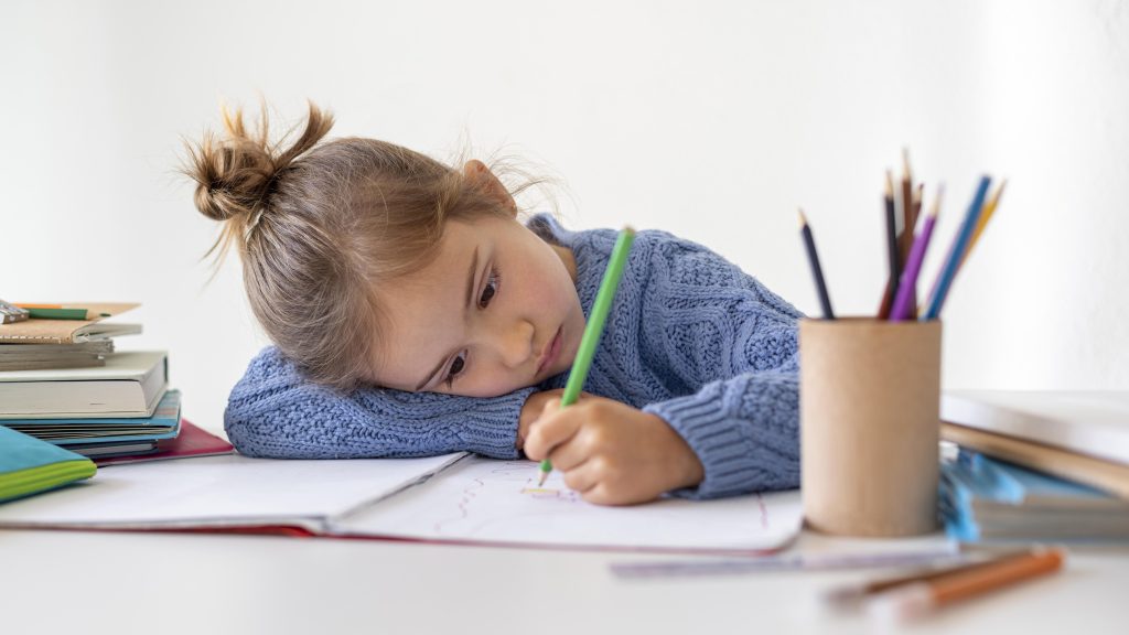 A child with OCD sitting on the tableand feeling upset.