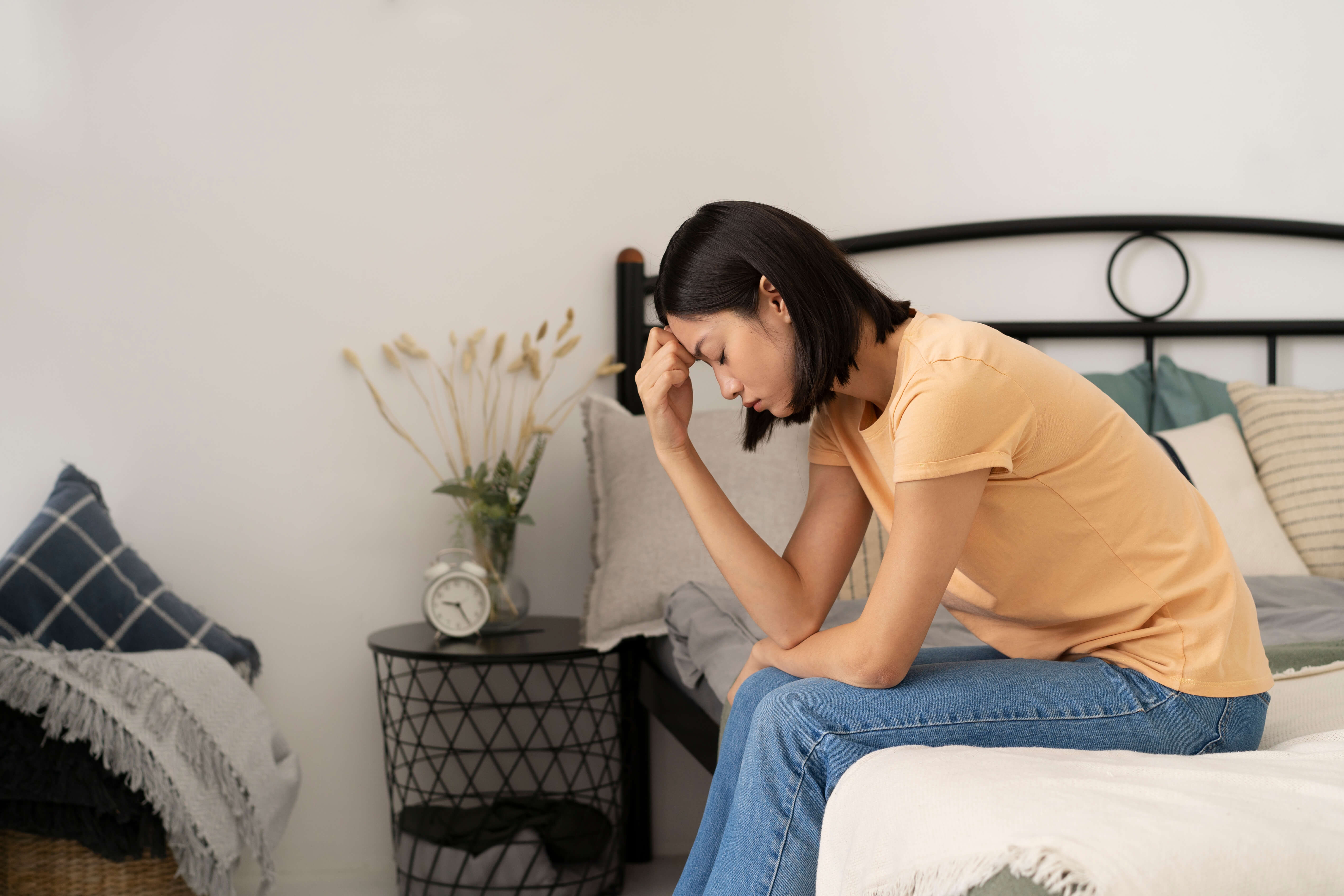 Person sitting on the couch and looking upset due to an anxiety attack