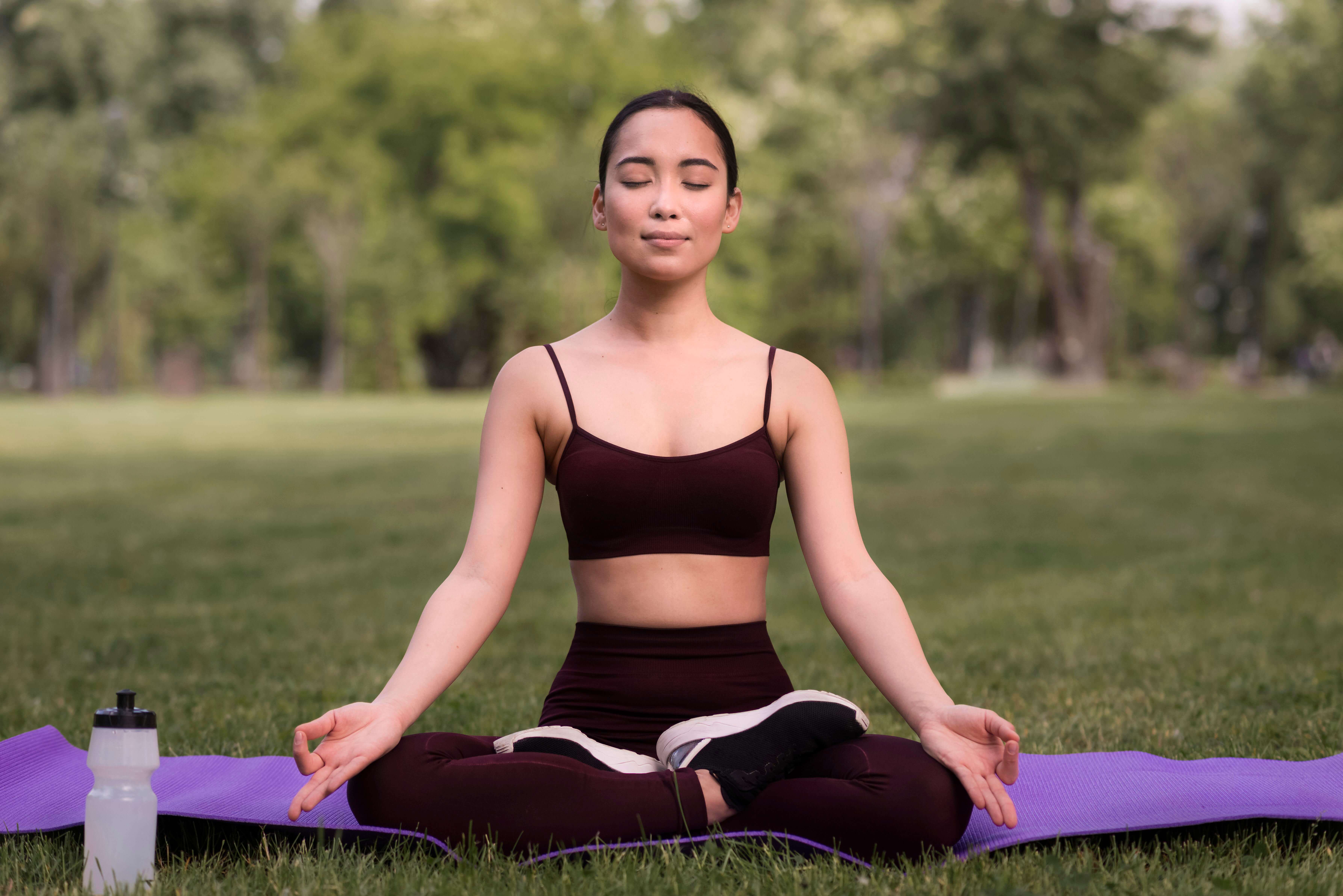 A person meditating in a park to control their anxiety attack