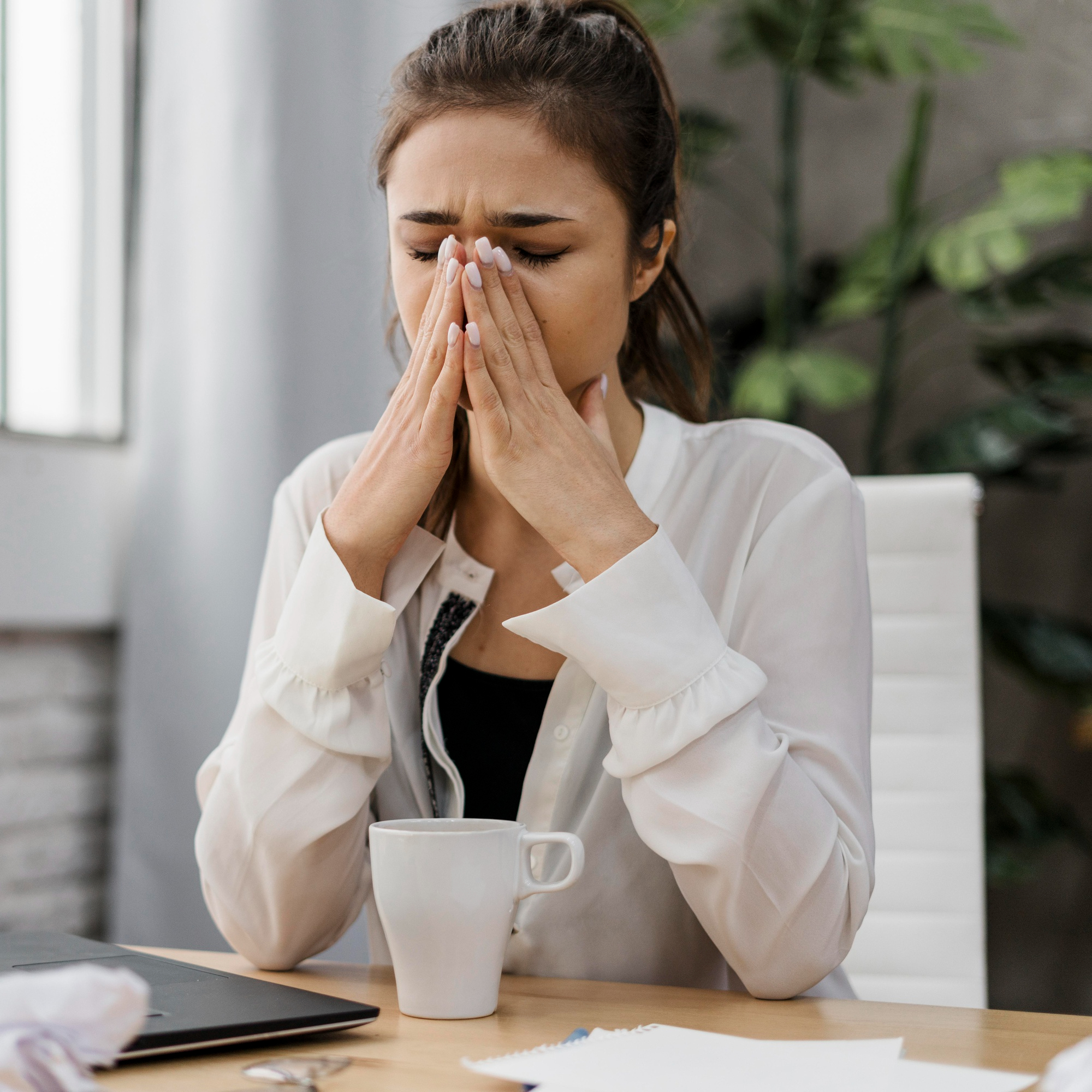 Businesswoman looking frustrated while working due to job loss anxiety.