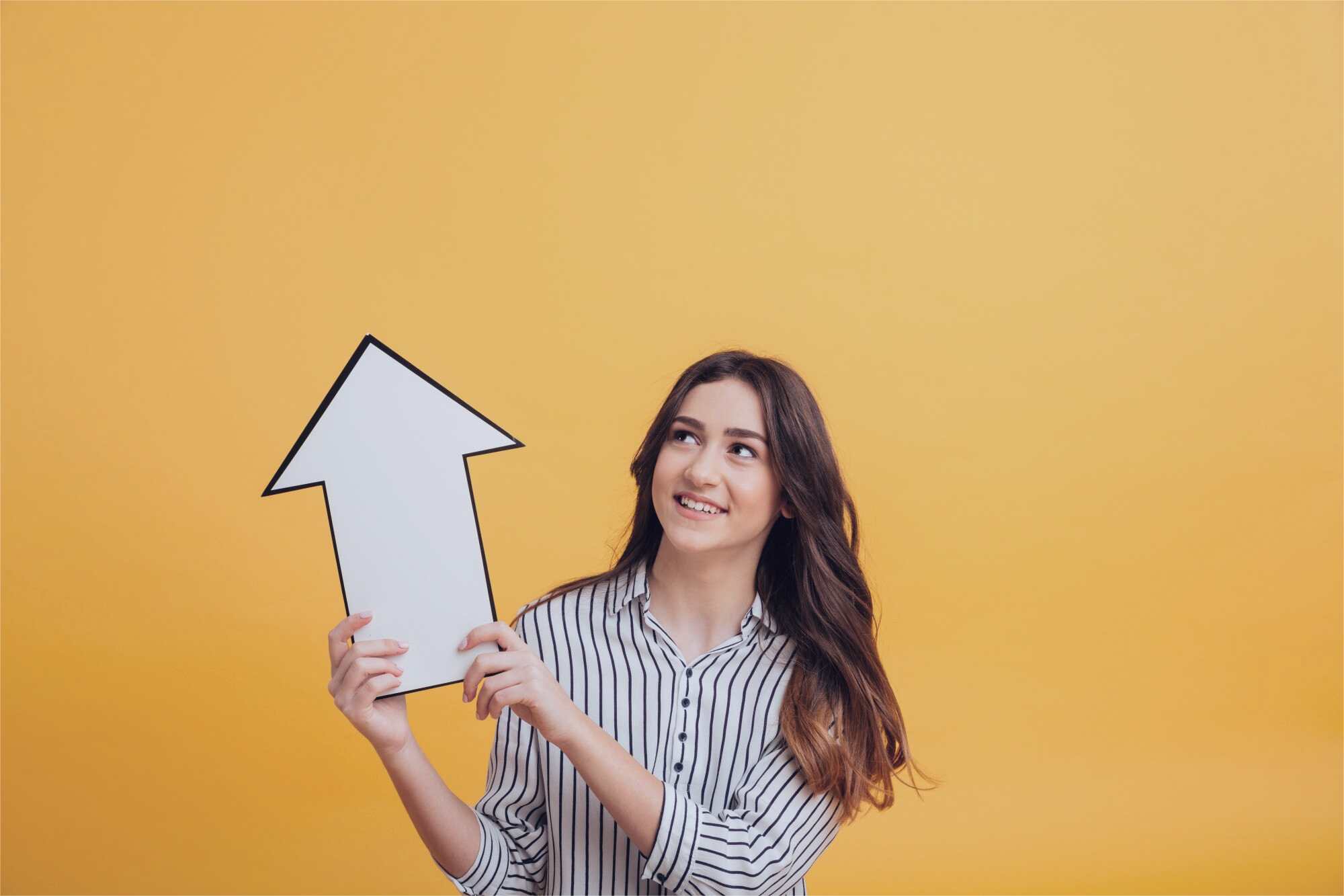 A person holding an arrow pointing upwards, signifying growth.